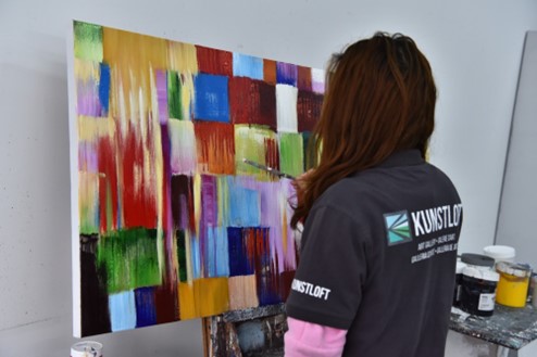 Künstlerin von KunstLoft malt abstraktes Bild