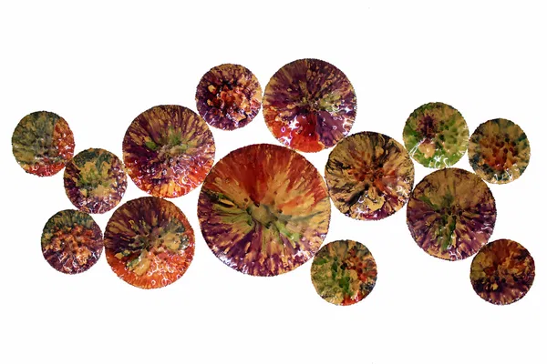 Lebendige Wandskulptur mit mehrfarbigen, strukturierten Metallscheiben, die an blühende Blumen oder Planeten erinnern.