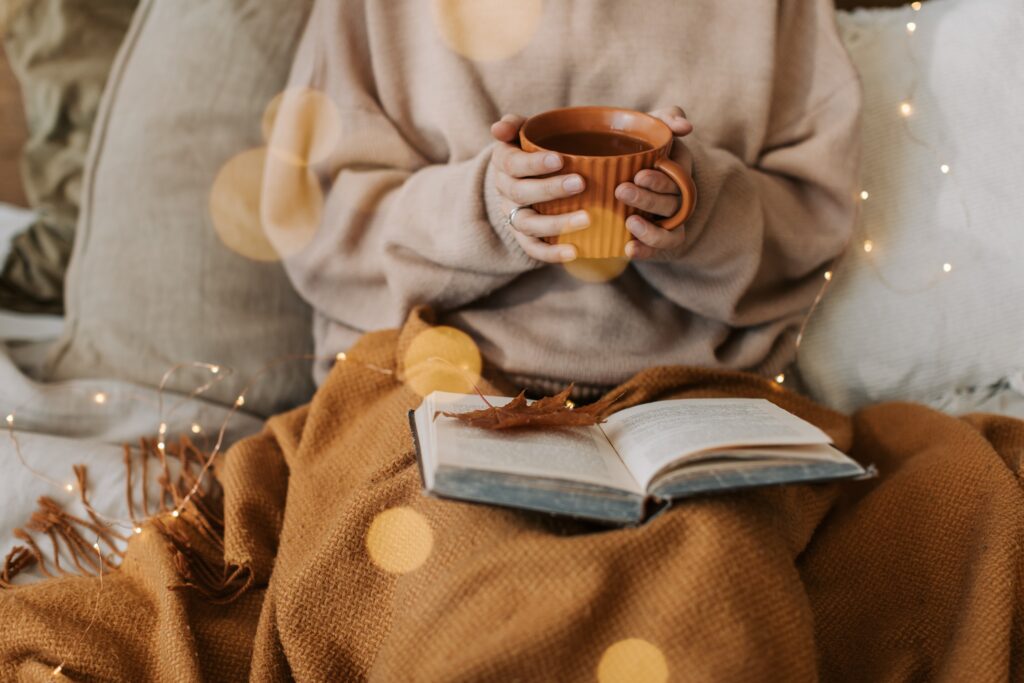 Eine Frau mit einer Tasse Kaffee in einer herbstlichen Stimmung