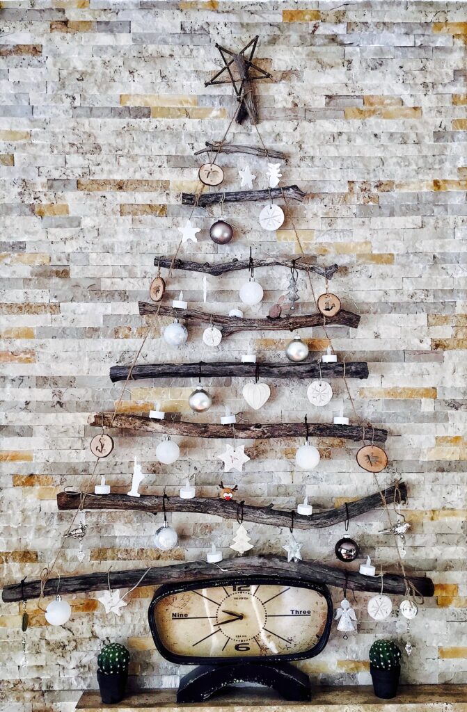 Eine moderne Weihnachtsbaum-Idee mit Holzstäben und einer Weihnachtskugel
