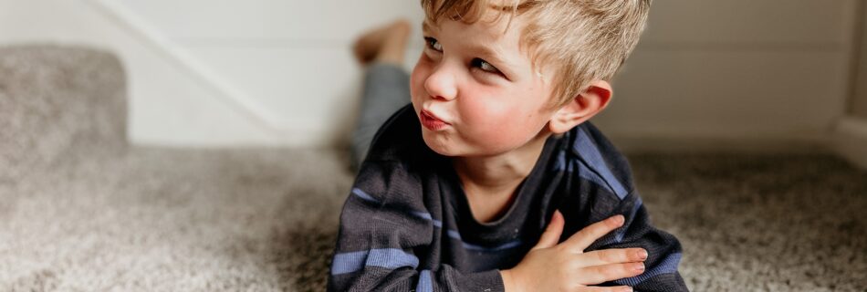 An image of a boy lying in a carpet