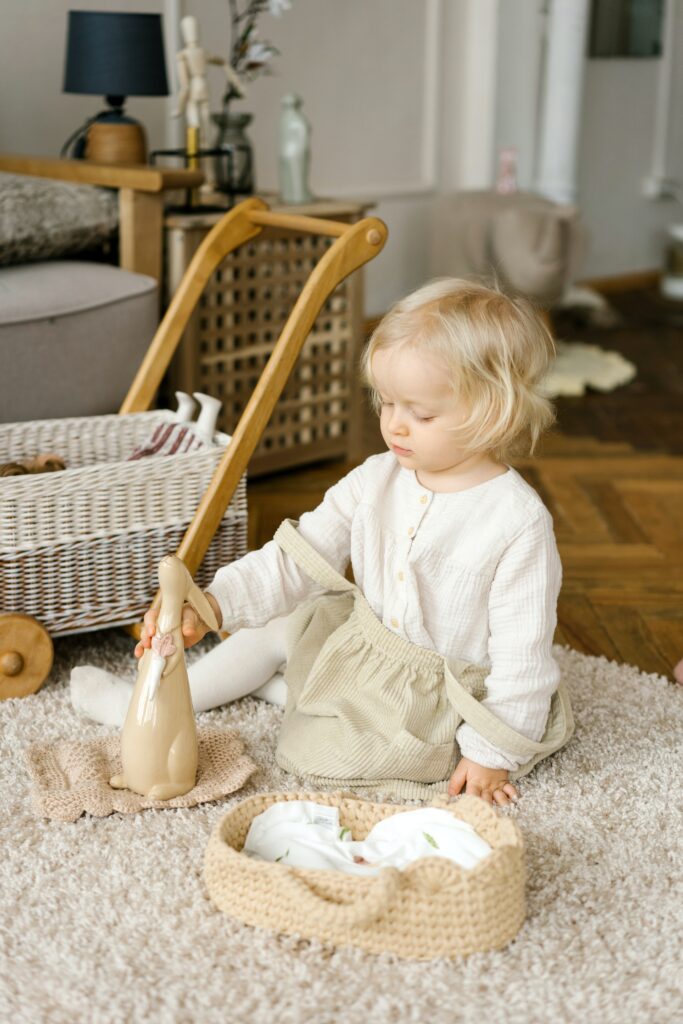 ein junges Mädchen, das auf dem Teppich sitzend sein Spielzeug platt macht