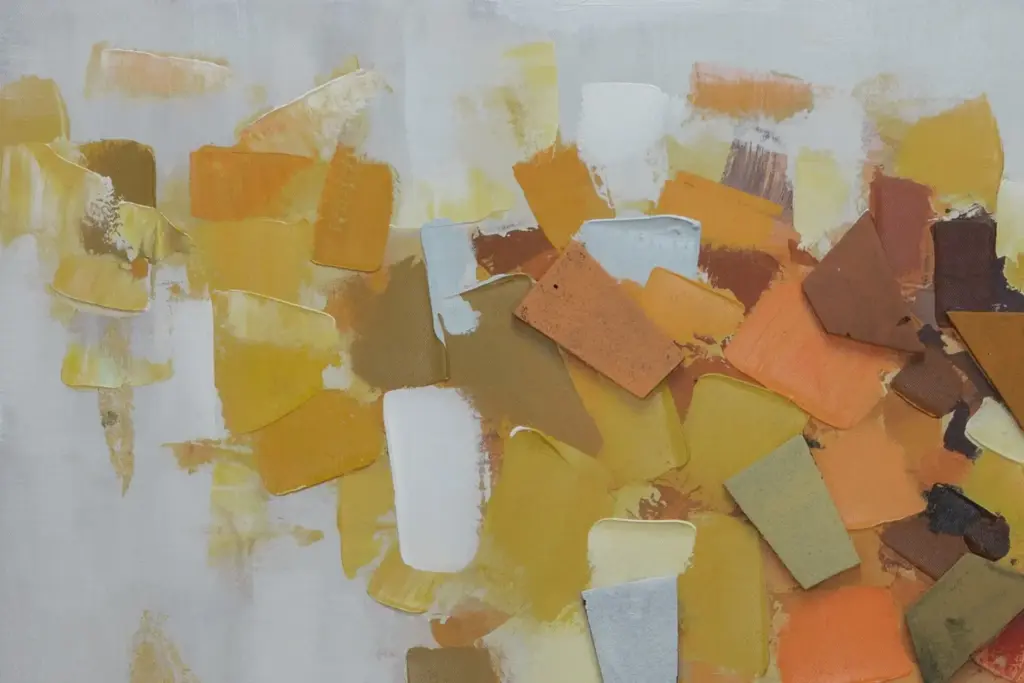 Eine Nahaufnahme eines abstrakten Impasto-Gemäldes, das dicke, strukturierte Spachtelstriche in Gold, Ocker und Terrakotta auf einer weißen Leinwand zeigt.