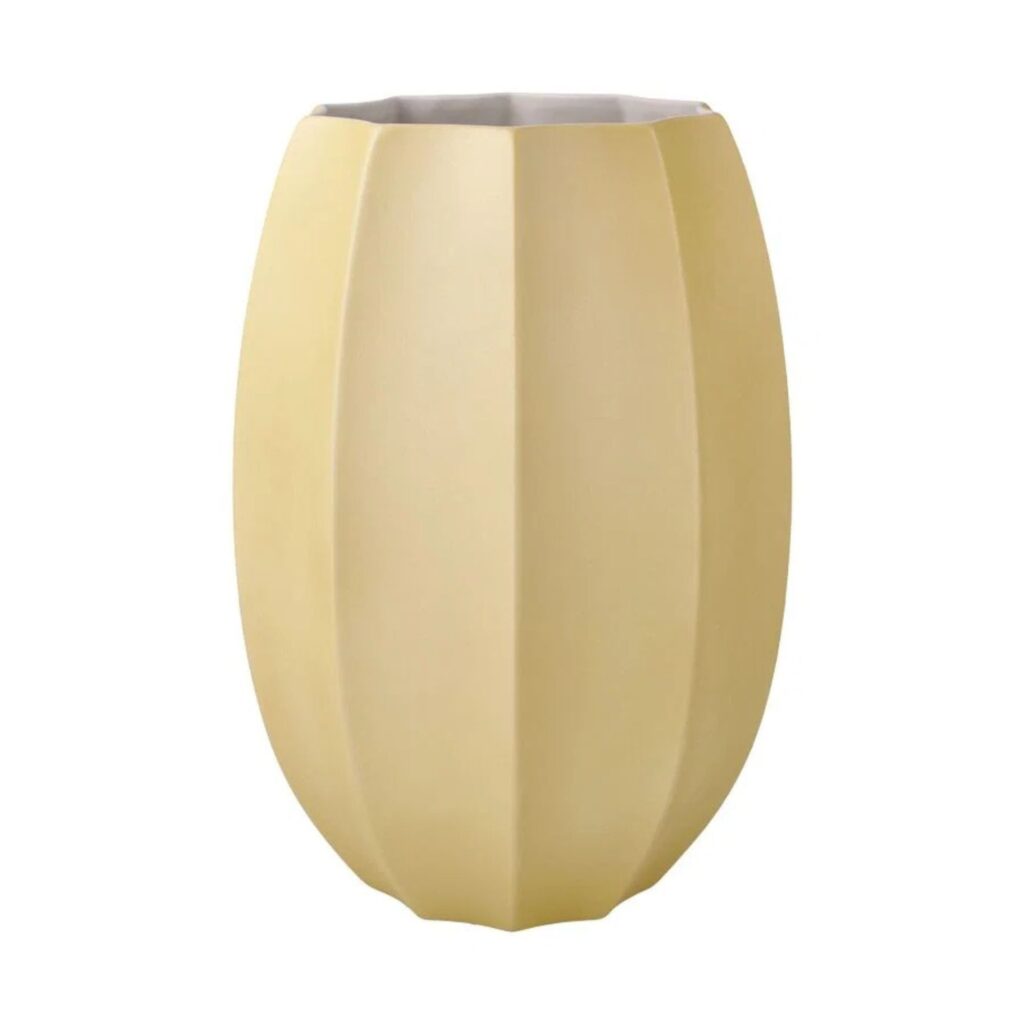 Eine Vase in gedämpftem Gelb mit facettierten geometrischen Formen.